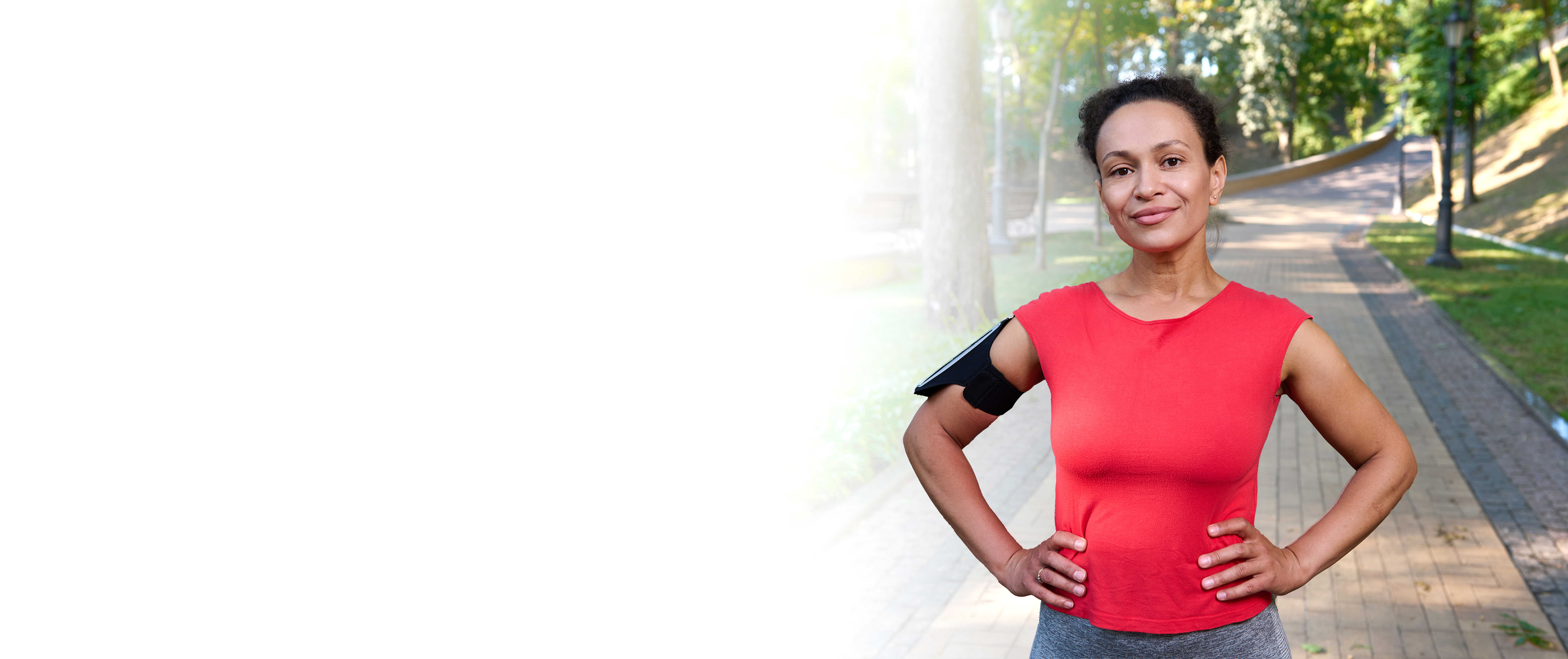 A women standing outside in a bright red athletic shirt