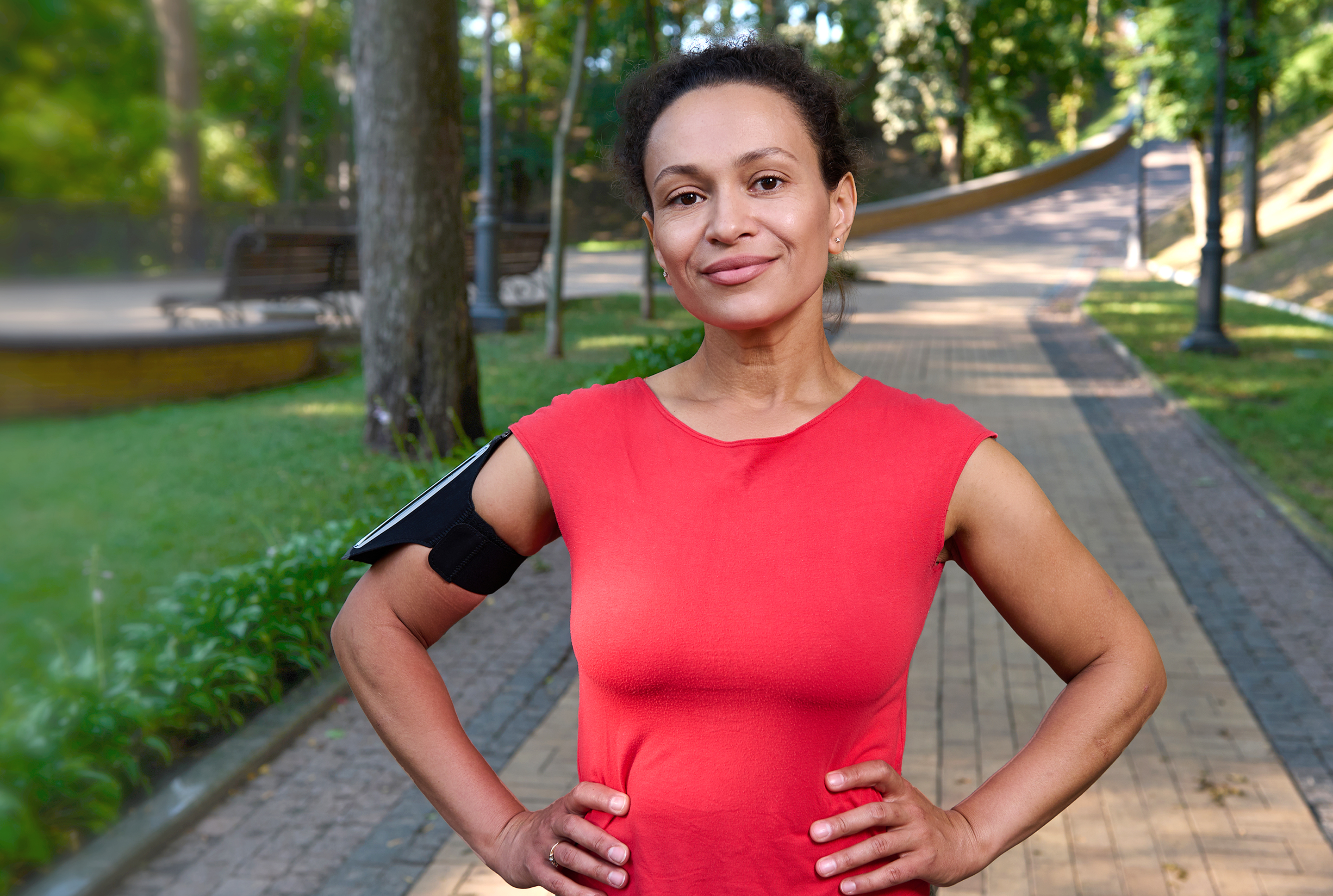 a woman in a bright red athletic shirt outside 