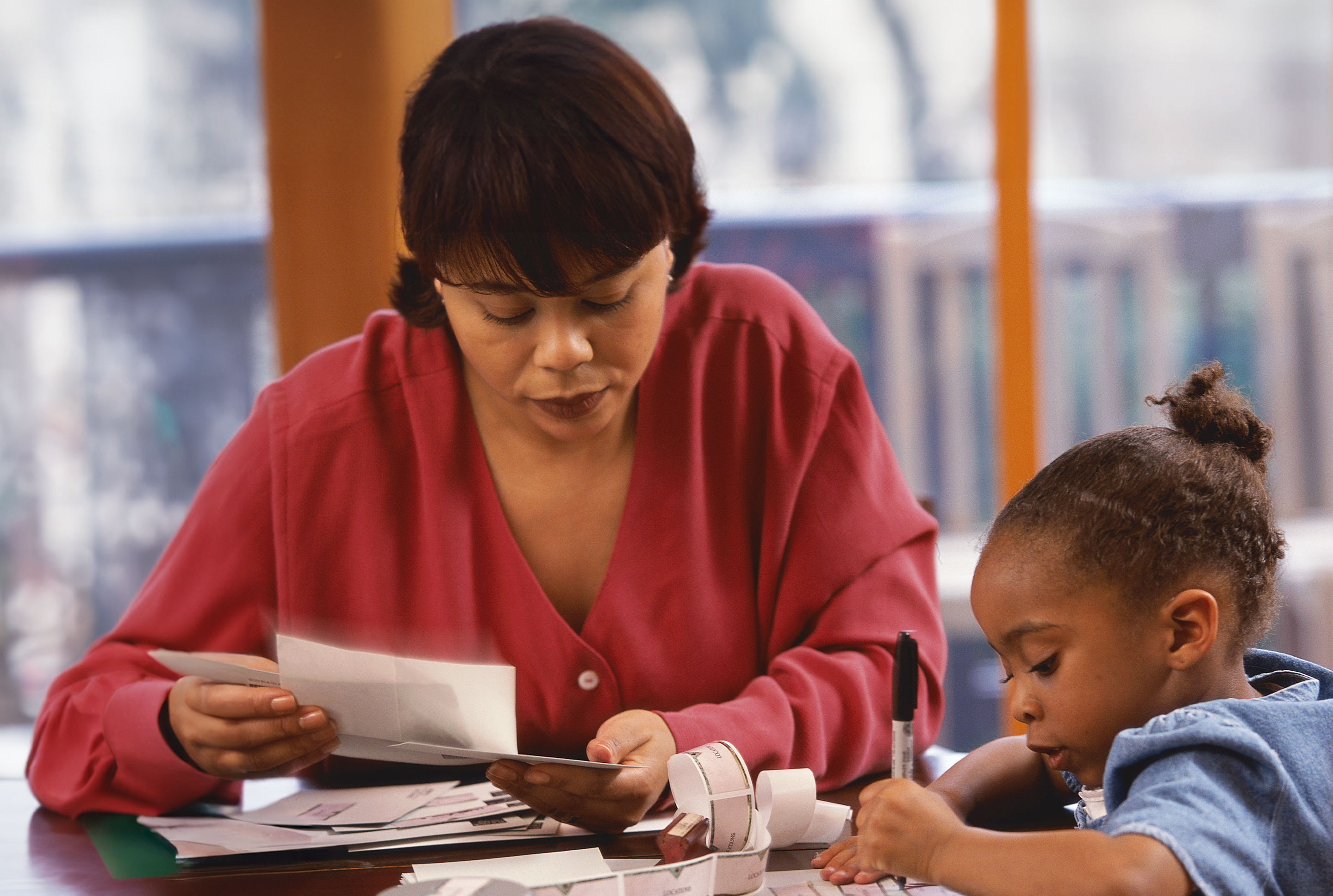 woman and young child at the table with papers