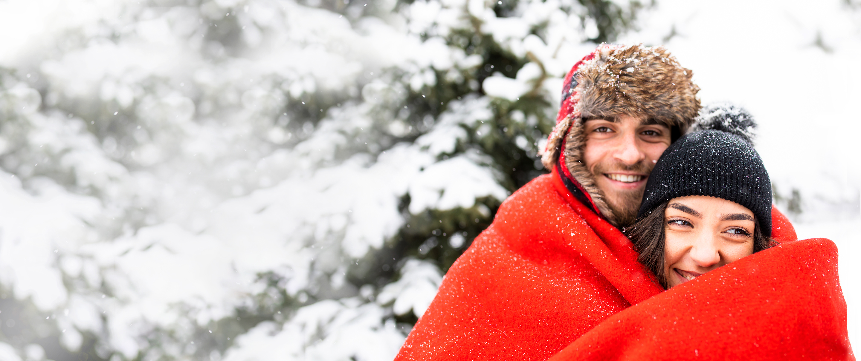 couple wrapped around a red blanket